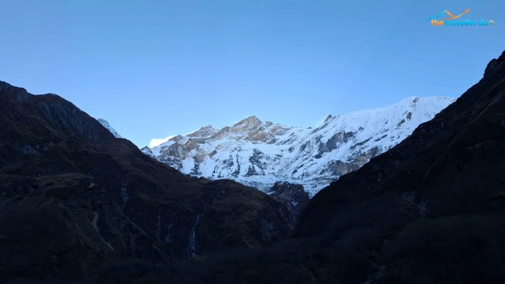 First morning sun on snow peaks of the Annapurna range above the dark Mistri Khola valley