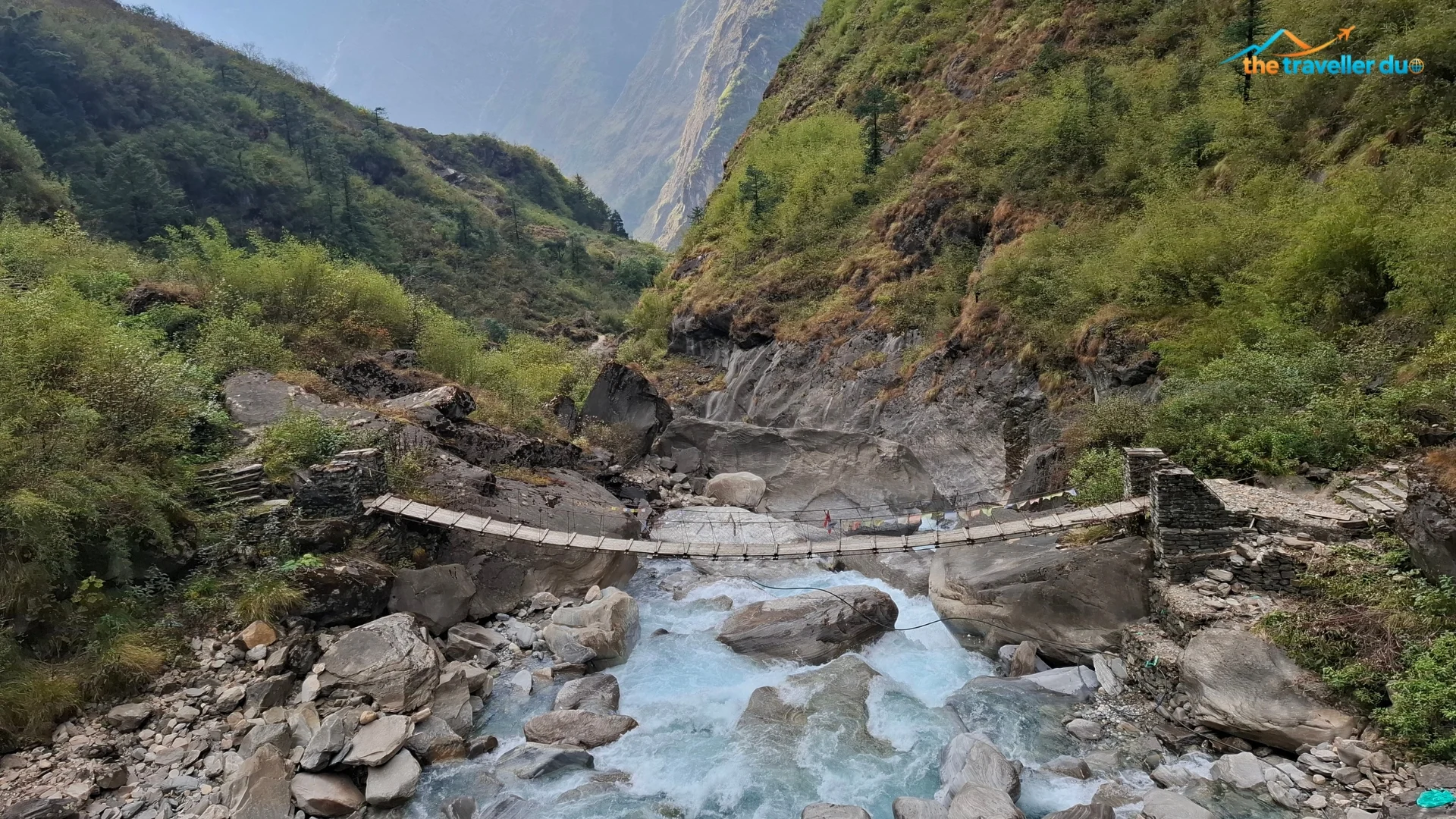 Wooden suspension bridge over the glacial blue Mistri Khola on the North ABC trek